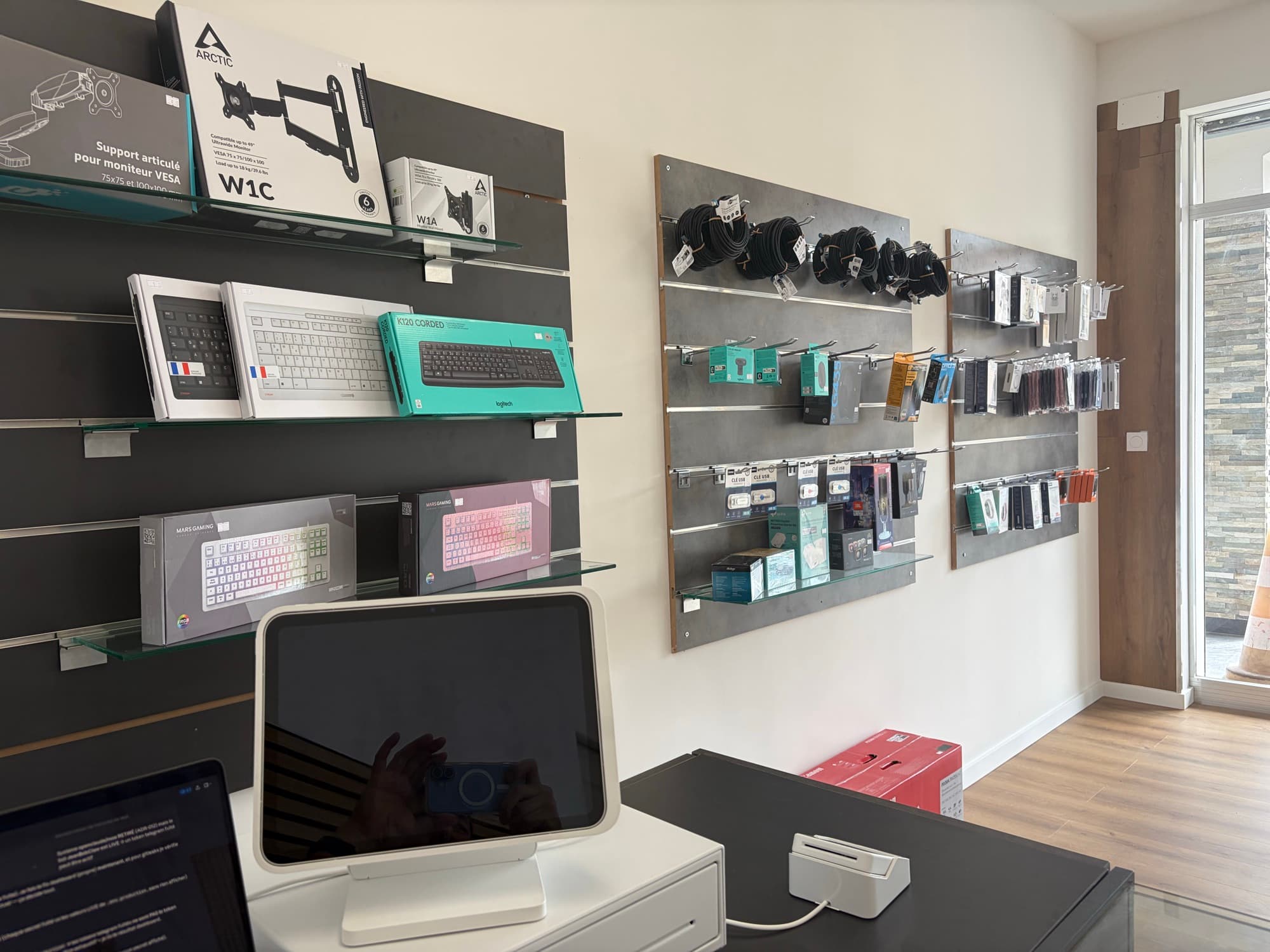 Le mur d'accessoires : claviers, câbles, casques, périphériques et imprimantes
